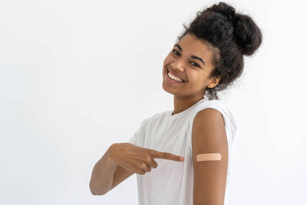 istock Smiling african girl pointing at plaster on arm 1361359827