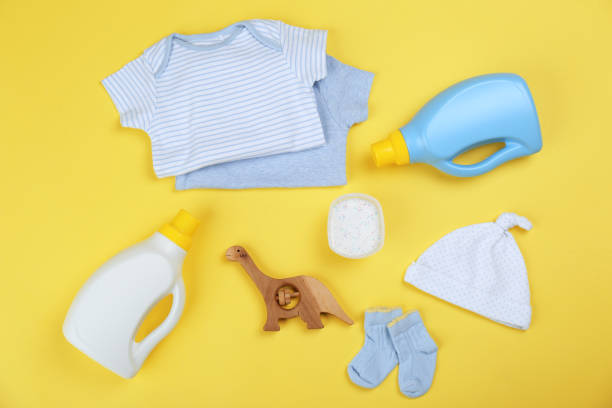 istock Flat lay composition with detergents and children's clothes on yellow background 1361359859