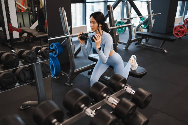 istock Woman shakes biceps doing exercises with dumbbells 1361359880