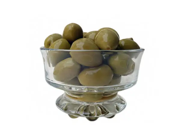 Close up front view of fresh green olives in a glass dish isolated on a white background, food cut out photo.