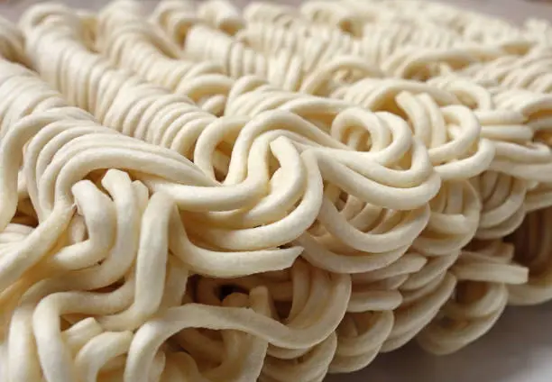 Close up view of dry noodles on blurred background.