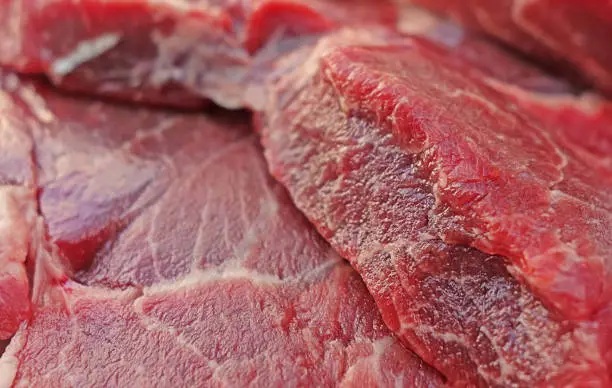 Close up view of raw beef steak, red blurred meat food background photo.