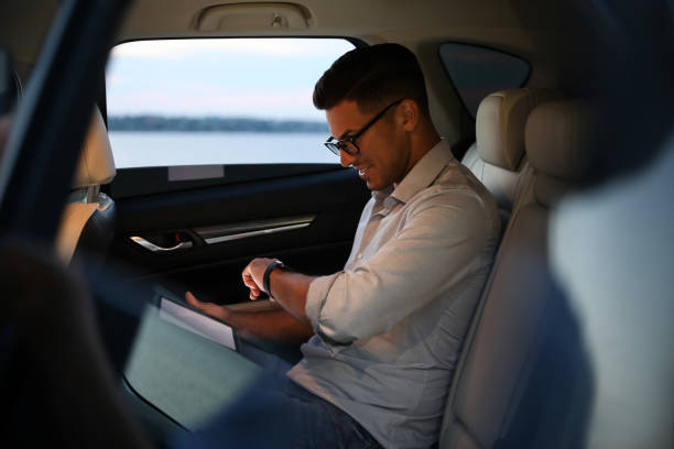 istock Handsome man using tablet on backseat of modern car 1361363006
