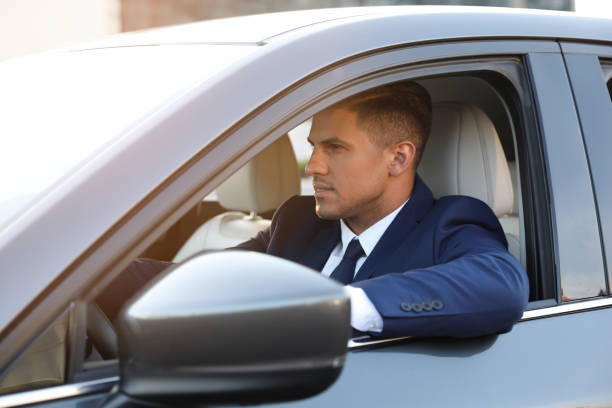 istock Handsome man driving his modern car, view from outside 1361365006