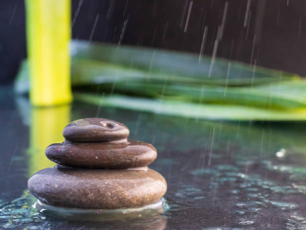 istock Zen stones with water on black background with leaves 1361365197