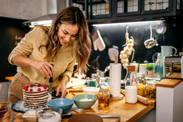 istock Smiling woman applying icing on pancake cake 1361365406