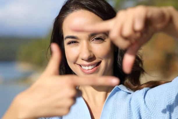 istock Front view of woman framing with hands looking at you 1361367899
