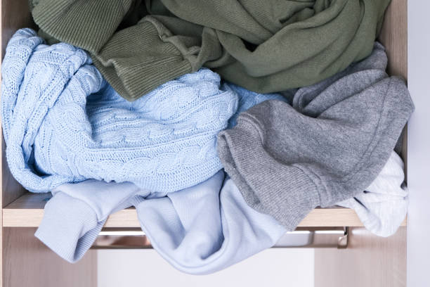 istock Clothes scattered in a mess on a wardrobe shelf, organization and decluttering needed 1361371203