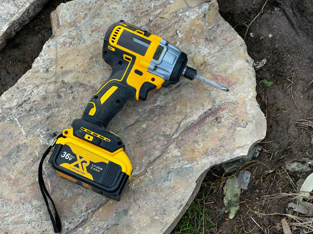 istock cordless screwdriver standing on rock on ground at construction site 1361372704