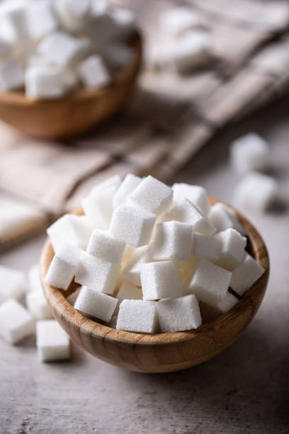 istock White sugar cubes in a wooden bowl on the table. 1361374026