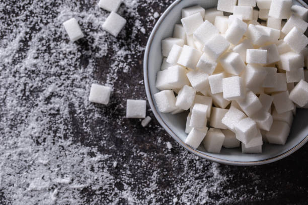 istock White sugar cubes in a blue bowl on the table. 1361374915