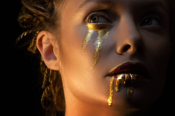 istock Mysterious mystical heroine with golden drops on her face, 1361375730