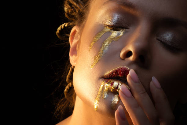 istock Mysterious mystical heroine with golden drops on her face, 1361375757