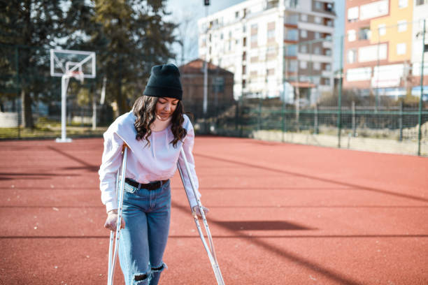 istock Determined Female Working On Improving Health By Walking With Crutches 1361385110
