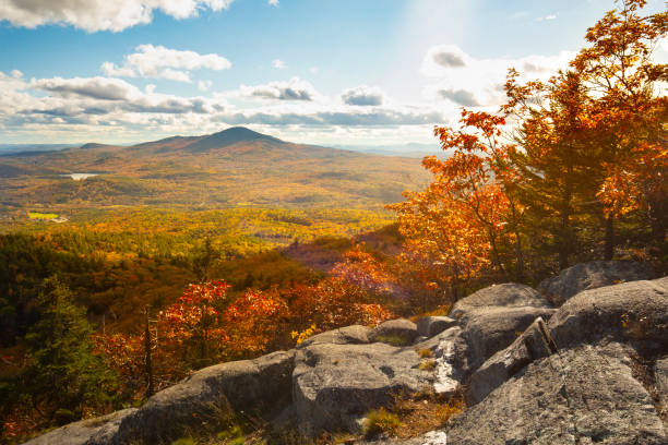 View of Mt. Kearsarge from Ragged Mountain in New Hampshire. Fall view from Ragged Mountain of Mt. Kearsarge in the distance, with fall foliage and granite ledges in Andover, New Hampshire. new hampshire stock pictures, royalty-free photos & images