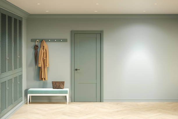 hall d’entrée vert dans un style classique moderne avec un mur vierge éclairé par un projecteur, une porte d’entrée, un cintre au-dessus d’un banc, une armoire intégrée, un parquet. vue de face. - closet hotel door contemporary photos et images de collection