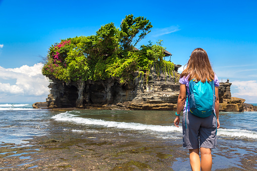 Woman traveler at  Tanah Lot temple on Bali, Indonesia in a sunny day
