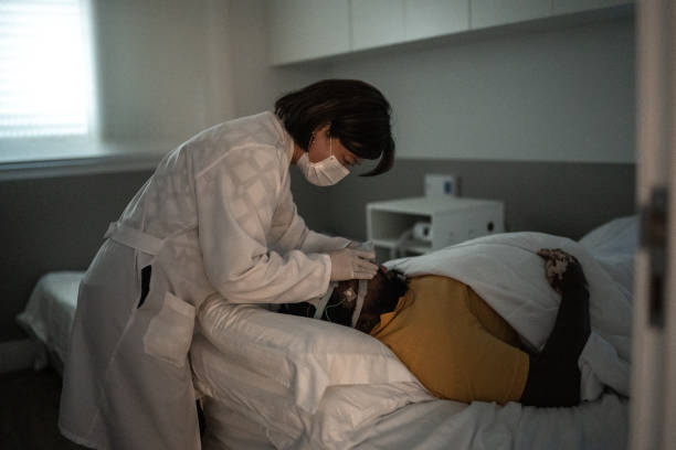 doctor placing electrodes on patients head for a medical exam wearing protective face mask