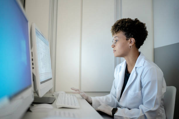 médica trabalhando no computador em uma clínica médica - registo médico eletrónico - fotografias e filmes do acervo