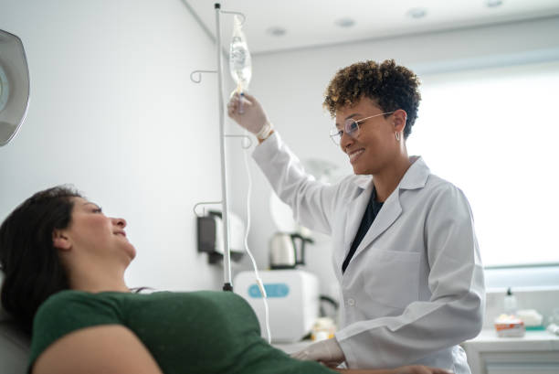 arzt spricht mit einem patienten und nimmt iv-tropf in einer medizinischen klinik - kochsalzlösung infusion stock-fotos und bilder