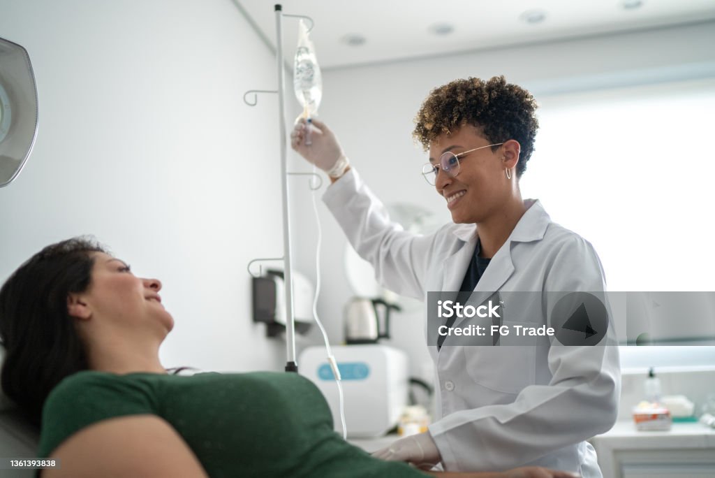 Doctor talking with a patient and taking IV drip at a medical clinic IV Drip Stock Photo