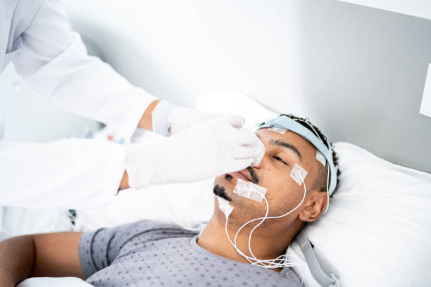 istock Doctor preparing patient in bed for polysomnography (sleep study) 1361394476