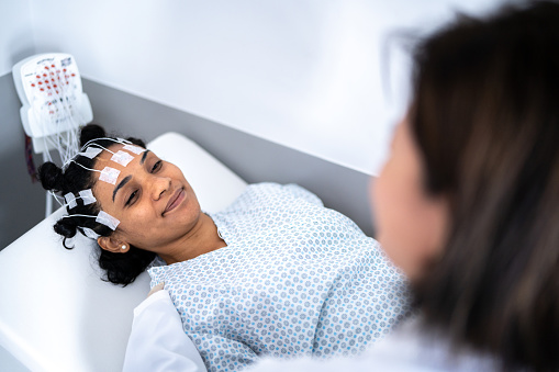 Doctor talking to patient's head before a polysomnography (sleep study)