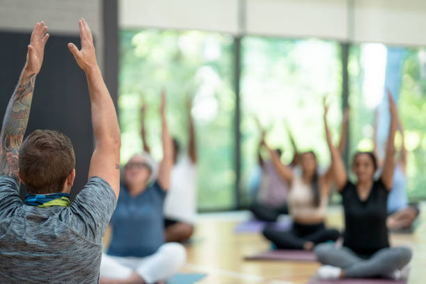 istock Male yoga instructor leads class 1361395487