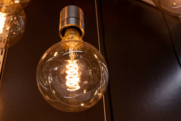 istock retro lighting.vintage glowing light bulbs on black background.Decorative antique edison style filament light bulb 1361396044