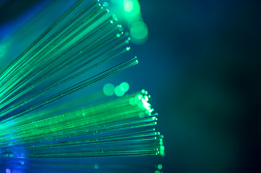 A DSLR close-up photo of fiber optics in green tones. Shallow depth of field, beautiful bokeh. Space for copy.