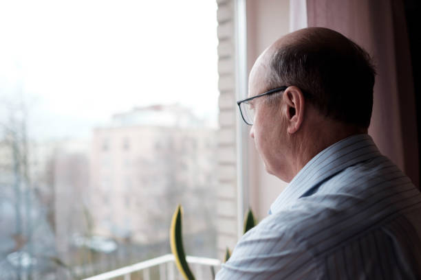 istock Elderly caucasian man looking out window with lonely expression 1361399204