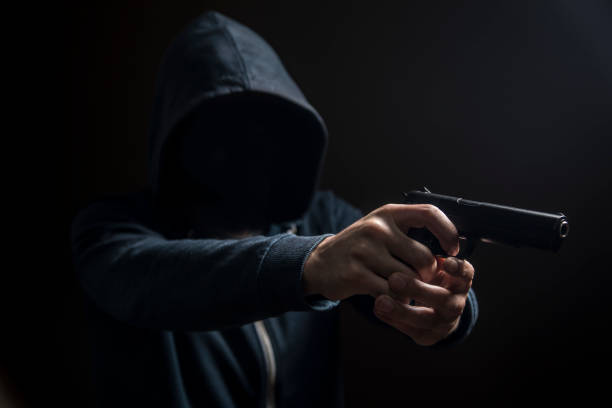 istock holding a gun on a dark background 1361400125