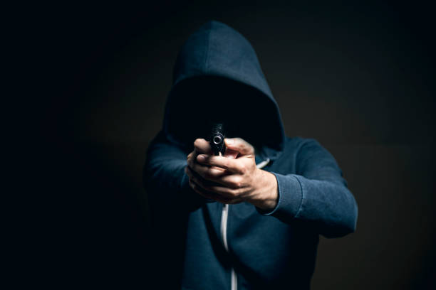 istock holding a gun on a dark background 1361400126