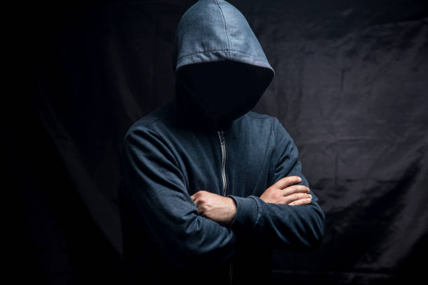 istock a man stands with his arms crossed on a dark background. 1361400137