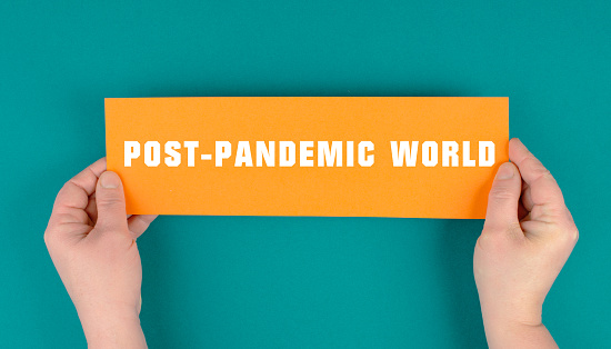 Las palabras mundo post-pandemia están de pie sobre un papel, la vida después del covid-19, la nueva normalidad, el estilo de vida futuro photo