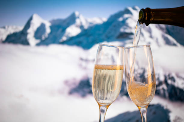 champagne glasses  and snowy peaks in background  New Year stock photo