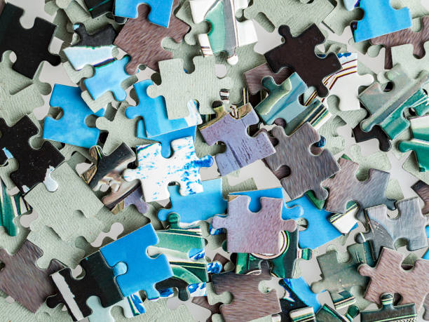 Scattered details of the puzzle mosaic, assembling a picture from puzzles, developing attention stock photo