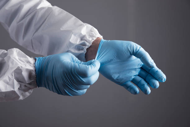 istock a doctor in a white protective uniform puts on a glove 1361404575