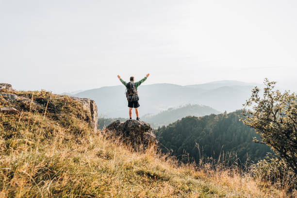 istock Hiker relaxes on grassy mountain ridge 1361404652