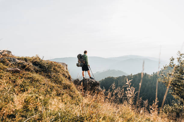 istock Hiker relaxes on grassy mountain ridge 1361405861