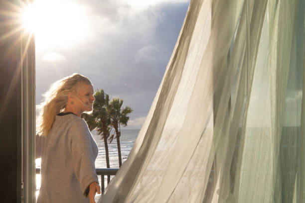 istock Woman relaxes on balcony at sunrise 1361406792