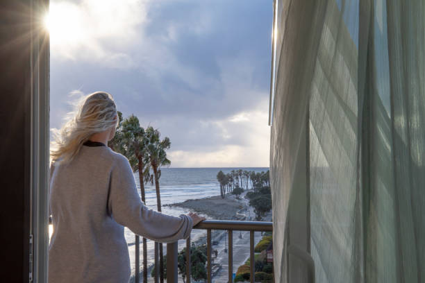 istock Woman relaxes on balcony at sunrise 1361407042