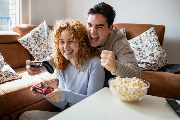 istock Young couple playing video games at home 1361407110