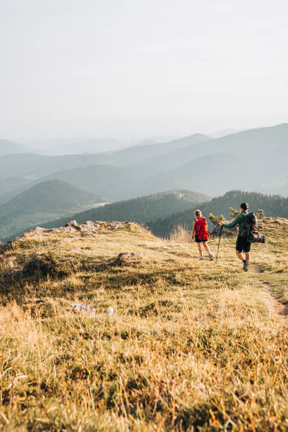 друзья ходят вдоль травянистого горного хребта - hiking young women outdoors t shirt стоковые фото и изображения