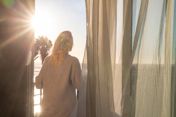 istock Woman relaxes on balcony at sunrise 1361407723