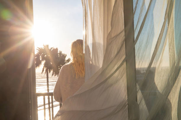 istock Woman relaxes on balcony at sunrise 1361407725
