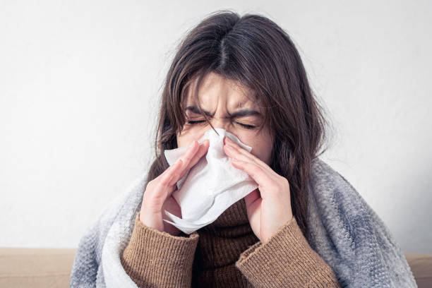 istock A sick young woman at home on the sofa with a cold. 1361407788