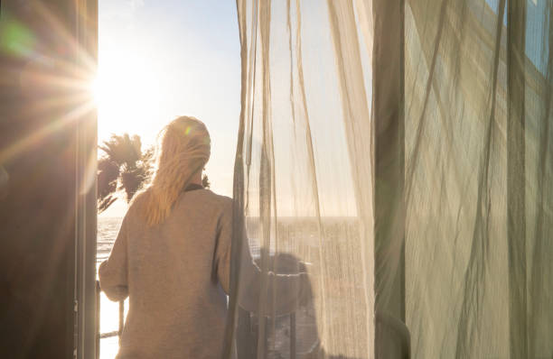 istock Woman relaxes on balcony at sunrise 1361407817