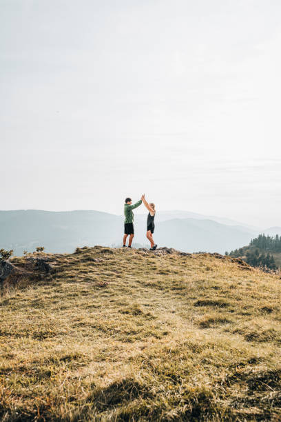 istock Hikers high-five on grassy mountain ridge 1361408323