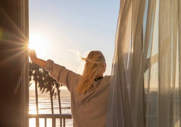 Woman relaxes on balcony at sunrise
